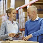 Shot of two colleagues having a work discussion while doing an inventory check in a warehouse