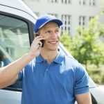 Happy Male Worker In Front Truck Talking On Mobile Phone